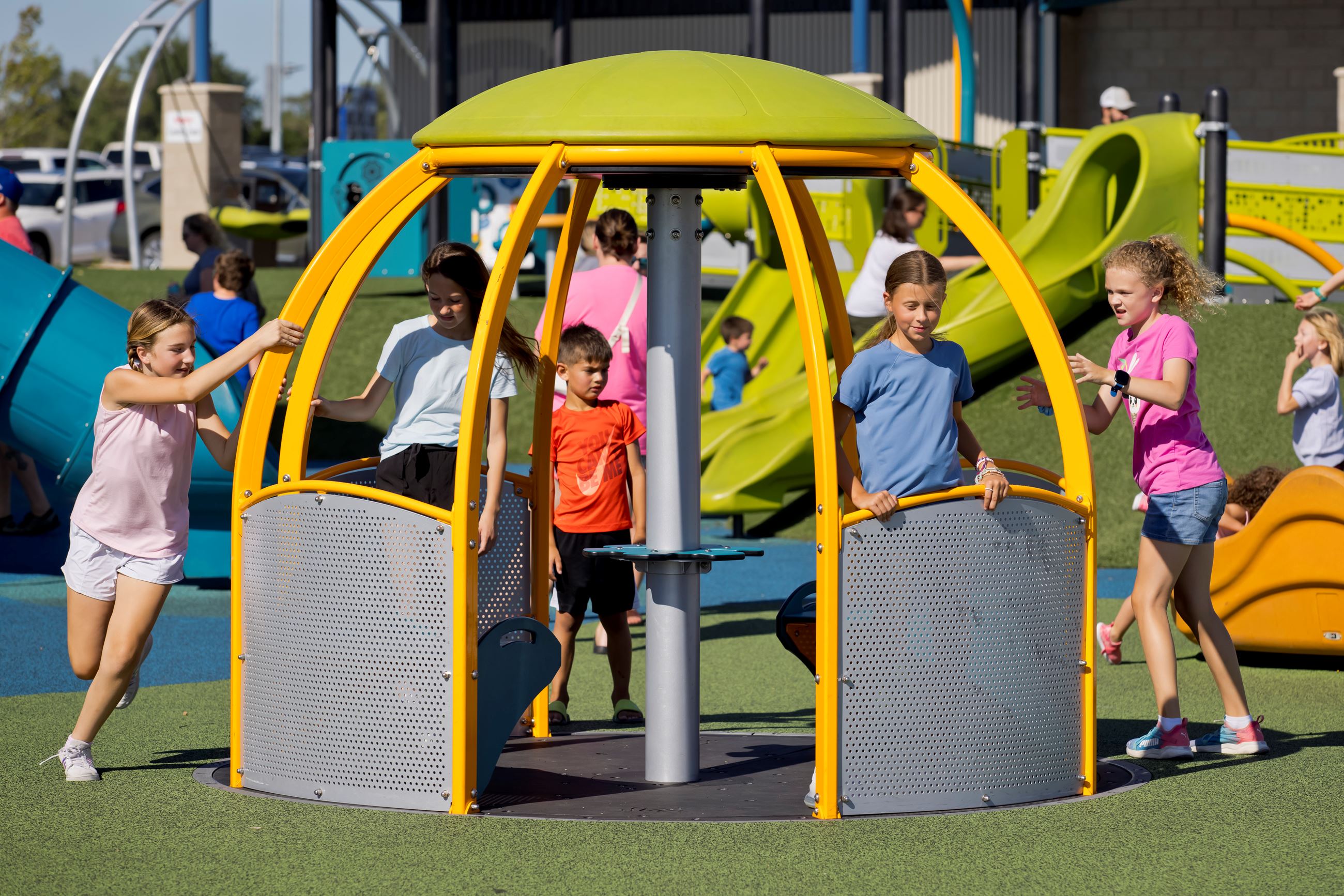 children ride inside and others push the roll-in, zero entry merry-go-round